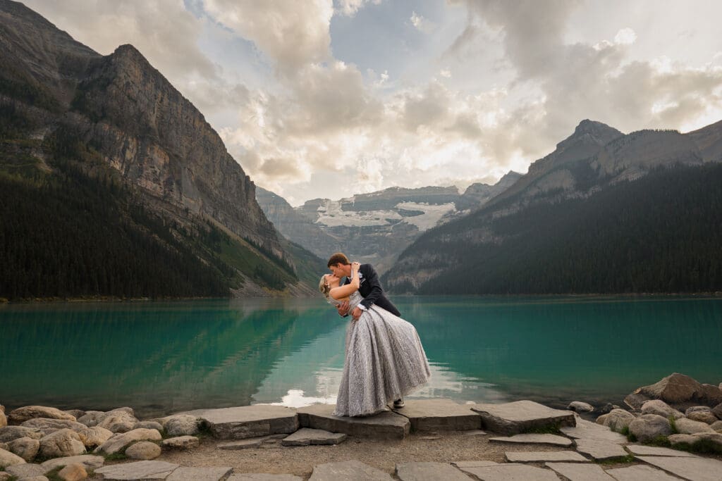Elopement couple kissing at sunset at Lake Louise in Banff