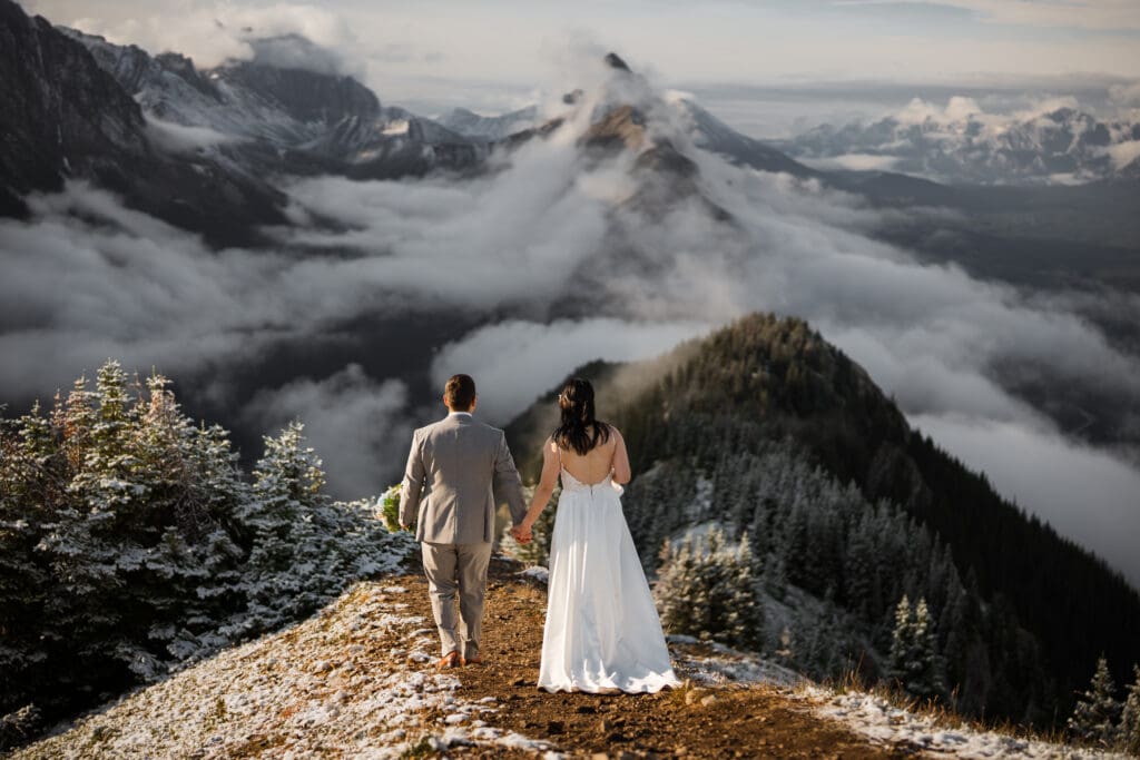 Couple walking down ridgeline in Kananaskis during hiking elopement